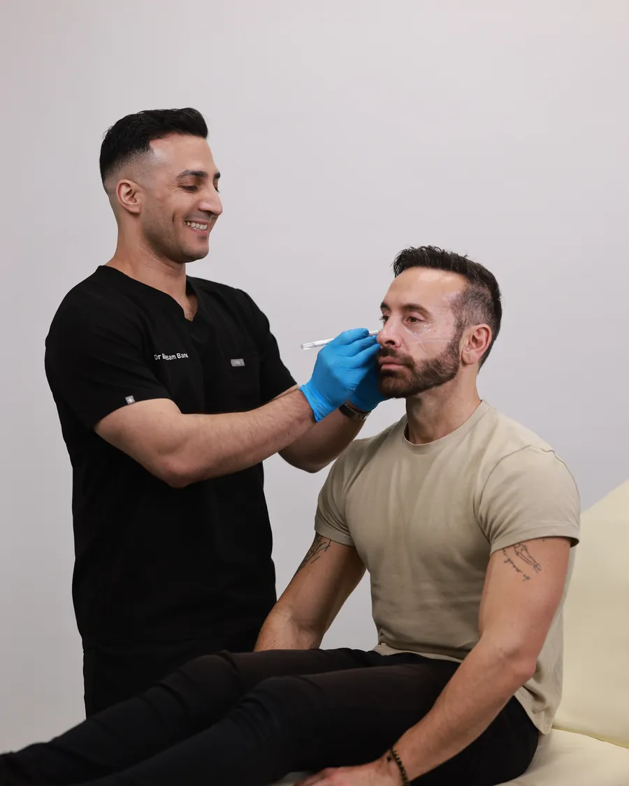 Dr Band assessing a male patient's face during a consultation