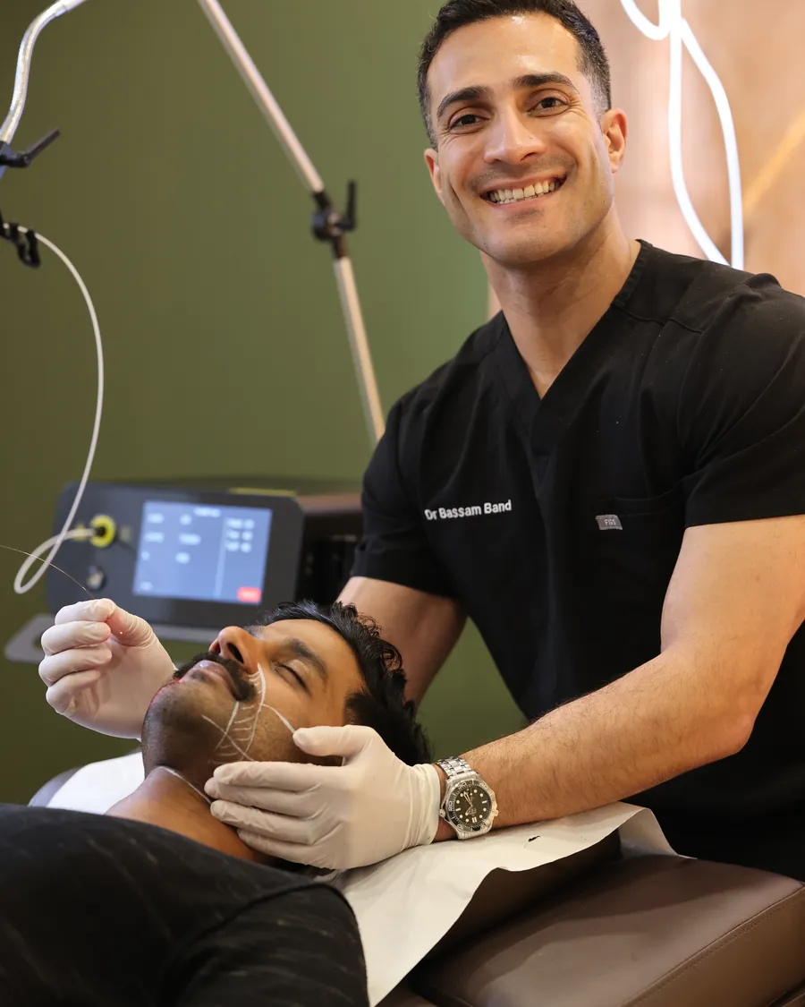 Dr Band smiling mid-session with a patient on the treatment bed